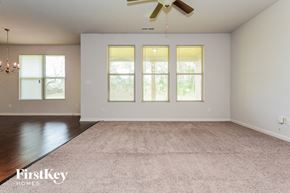 Mcdonough house for rent - A spacious room with a carpeted floor and a ceiling fan.