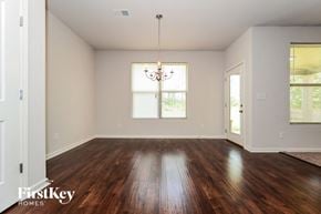 Mcdonough house for rent - A room with wooden floors and a chandelier hanging from the ceiling.