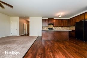 Mcdonough house for rent - A kitchen with wooden floors and a black refrigerator.