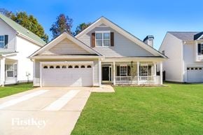Newnan house for rent - a white house with a lawn and a white garage door