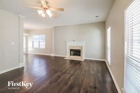 Newnan house for rent - a living room with a fireplace and a ceiling fan