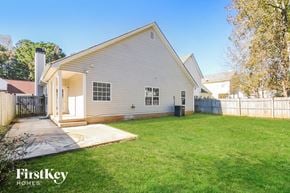 Newnan house for rent - a white house with a grass yard and a deck