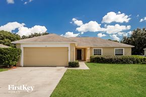 Auburndale house for rent - a beige house with a lawn and a garage door