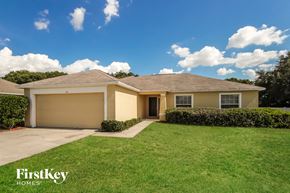 Auburndale house for rent - a beige house with a lawn and a sidewalk
