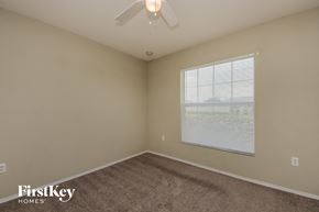 Auburndale house for rent - a bedroom with a large window and a ceiling fan