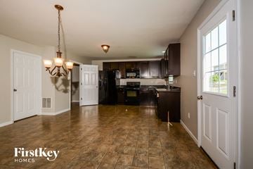 O'fallon house for rent - a kitchen with black cabinets and a large window