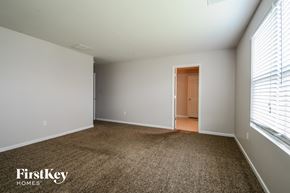 O'fallon house for rent - a master bedroom with a carpeted floor and a large window