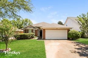 Covington house for rent - a house with a garage door and a lawn