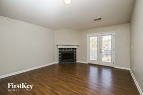 Covington house for rent - an empty living room with a fireplace and wood flooring