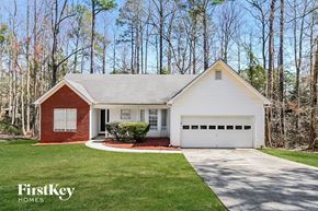Mcdonough house for rent - a small white house with a driveway and a garage door