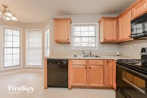 Mcdonough house for rent - a kitchen with wooden cabinets and black appliances