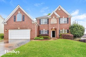 Mcdonough house for rent - A brick house with a garage door and a green lawn.
