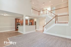 Mcdonough house for rent - A spacious living area with a staircase leading to the upper floor.