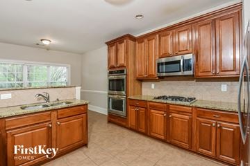 Mcdonough house for rent - A kitchen with wooden cabinets and a granite countertop.