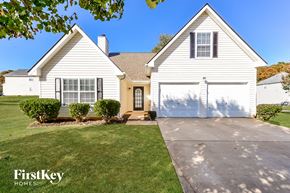 Covington house for rent - A white house with a brown roof and a garage door.