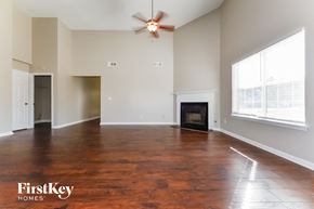 Covington house for rent - A spacious living room with a fireplace and wood flooring.