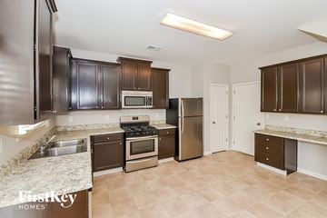 Hiram house for rent - A kitchen with brown cabinets and a stove top oven.
