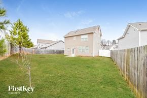 Hiram house for rent - A grassy yard with a fence and a house in the background.
