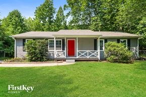 Dacula house for rent - A house with a red door and a green lawn in front.