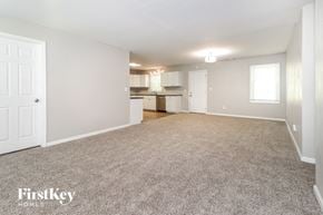 Dacula house for rent - A spacious empty room with a carpeted floor and white walls.