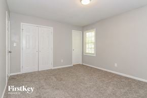 Dacula house for rent - A bedroom with a carpeted floor and a window with blinds.