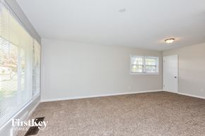 Florissant house for rent - a spacious living room with white walls and a large window