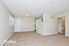 Florissant house for rent - a spacious living room with white walls and a carpeted floor