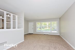 Florissant house for rent - a living room with a large window and white shelves