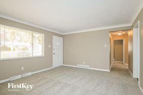 Saint Louis house for rent - the living room of an empty house with carpet and a large window