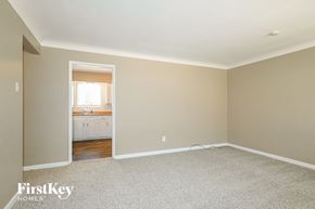 Saint Louis house for rent - a bedroom with carpet and a doorway to a bathroom