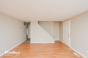 Chicago Heights house for rent - a living room with white walls and wooden floors and a staircase