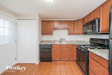 Chicago Heights house for rent - a kitchen with wood cabinets and black appliances
