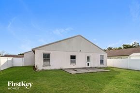 Winter Haven house for rent - a white house with a grassy yard and a white fence