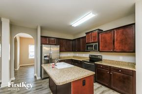 Dallas house for rent - a kitchen with granite counter tops and wooden cabinets