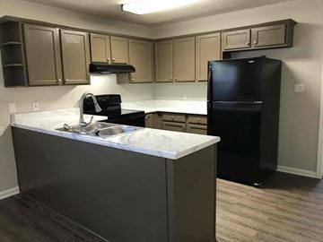 Helena house for rent - a kitchen with a sink and a black refrigerator