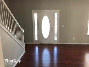 Newnan house for rent - A room with a wooden floor and a white door with a window above it.