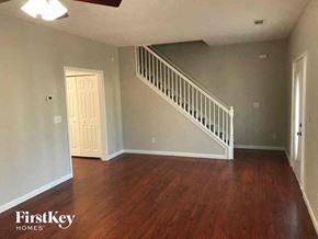 Newnan house for rent - A room with wooden floors and a staircase.