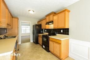 Braselton house for rent - a kitchen with black appliances and wooden cabinets