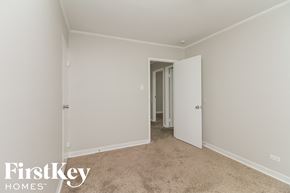 Park Forest house for rent - a bedroom with white walls and carpet and a door to a closet
