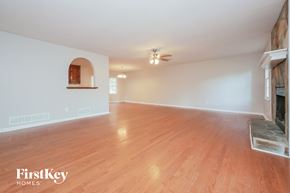 Newnan house for rent - an empty living room with a fireplace and wood flooring