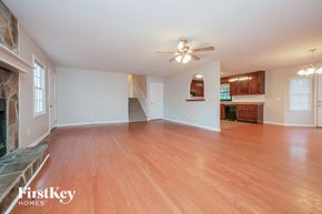 Newnan house for rent - an empty living room with wood flooring and a ceiling fan
