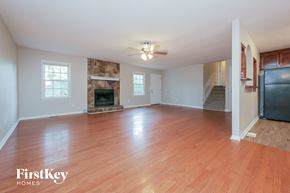 Newnan house for rent - an empty living room with wood flooring and a fireplace