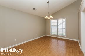 Alabaster house for rent - A room with wooden floors and a chandelier hanging from the ceiling.