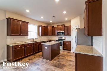 Moncks Corner house for rent - A kitchen with wooden cabinets and a refrigerator.