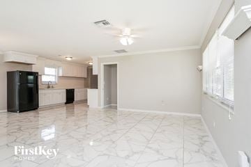 Lehigh Acres house for rent - a kitchen with white cabinets and a black refrigerator