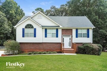 Winder house for rent - a white house with blue shutters and a lawn