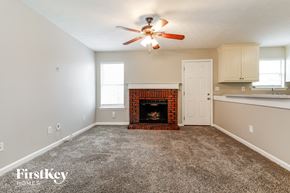 Winder house for rent - an empty living room with a brick fireplace and a ceiling fan