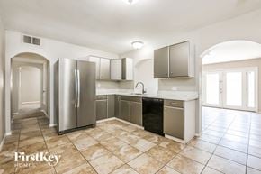 Phoenix house for rent - a large kitchen with stainless steel appliances and tile flooring