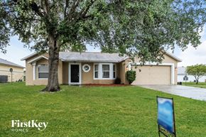 Poinciana house for rent - A house with a tree in front of it and a sign that says Firstkey Homes.