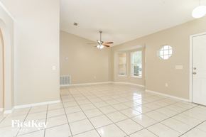 Poinciana house for rent - A spacious room with a fan and a window.